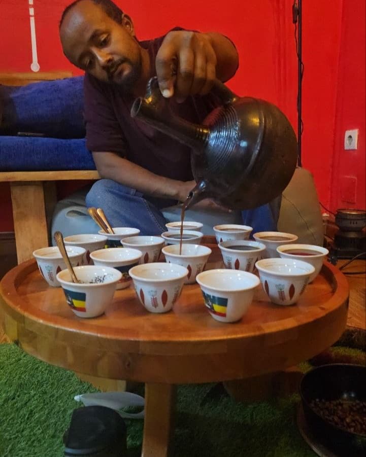 Semere pouring coffee at a traditional Ethiopian coffee ceremony